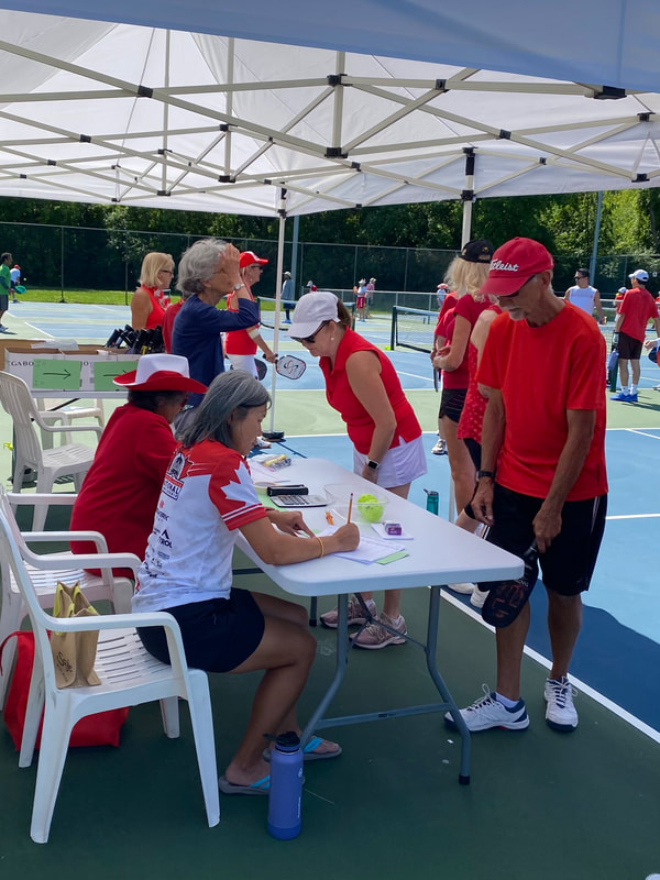 Players at the score table under the tents