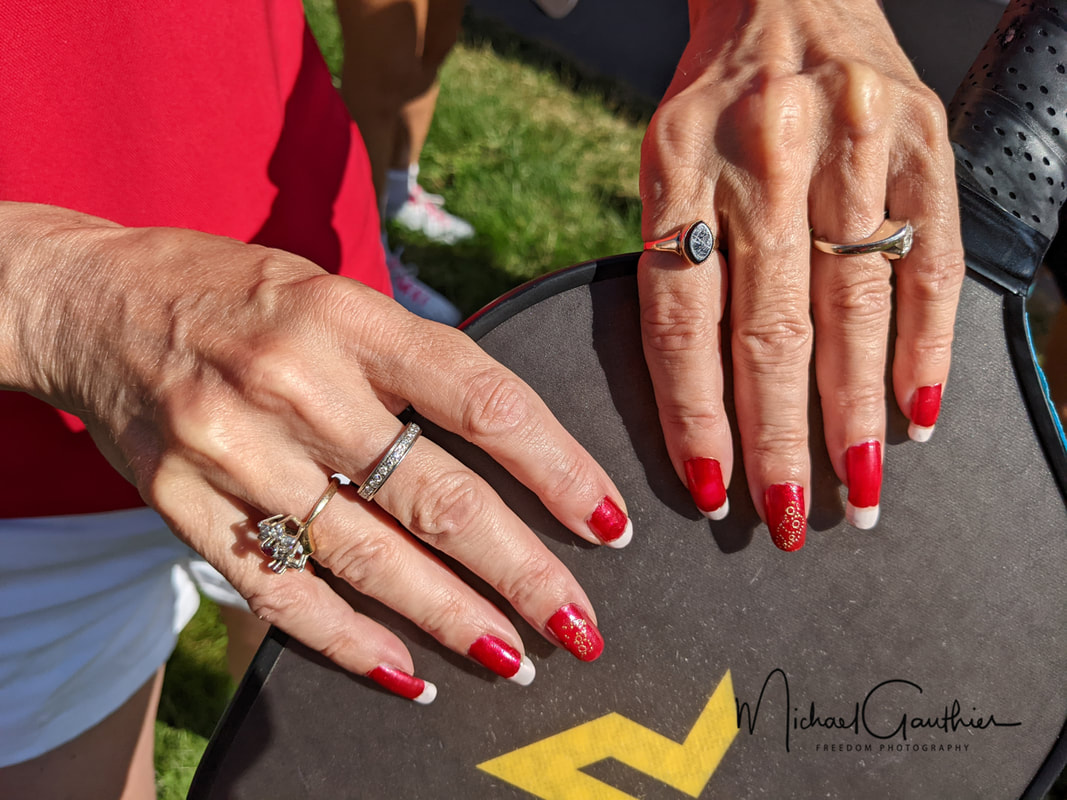 Close-up of red-painted nails on a paddle