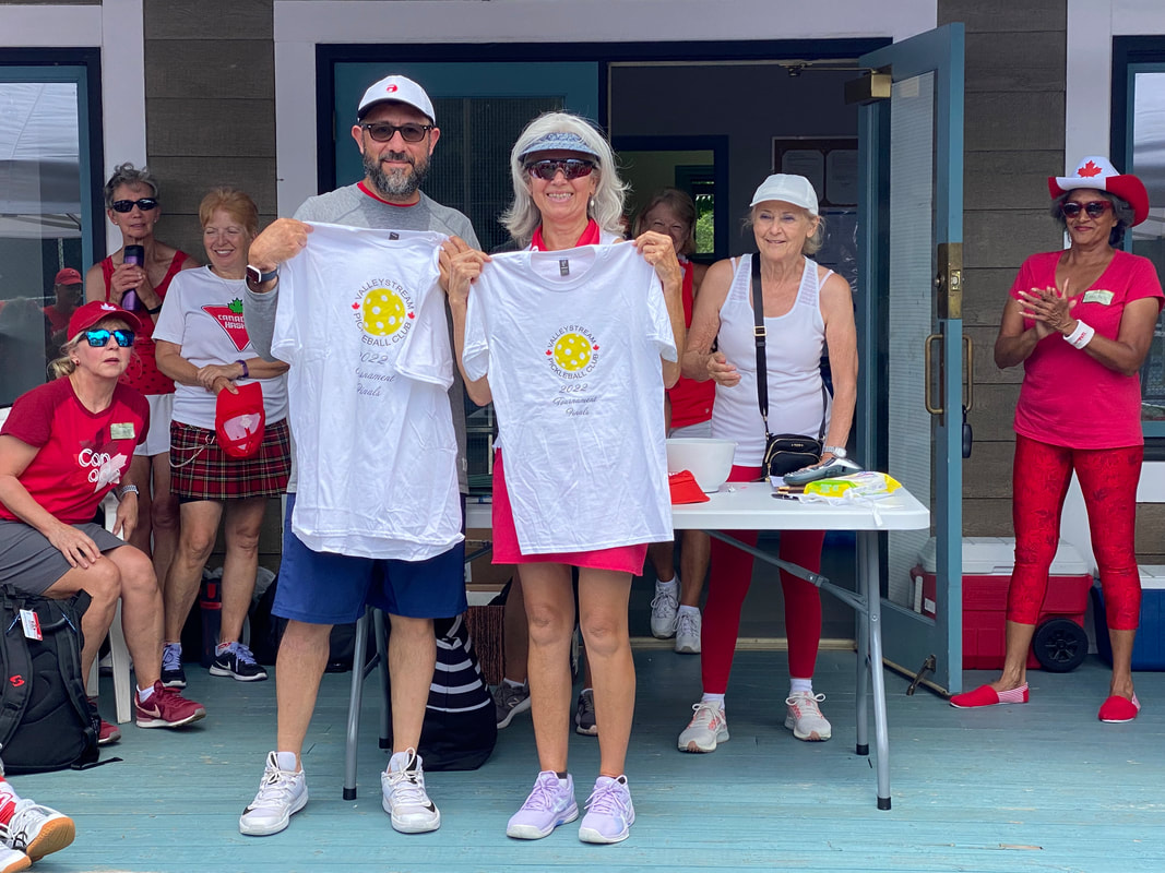 Two players holding prize shirts