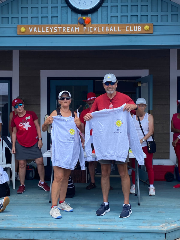 The two champions holding their 2022 Champion sweatshirts
